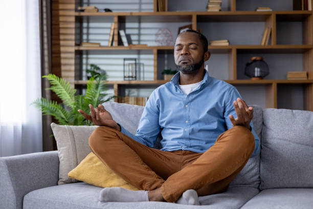 istock Adult man practicing meditation on living room sofa for inner peace and mindfulness 2148470248