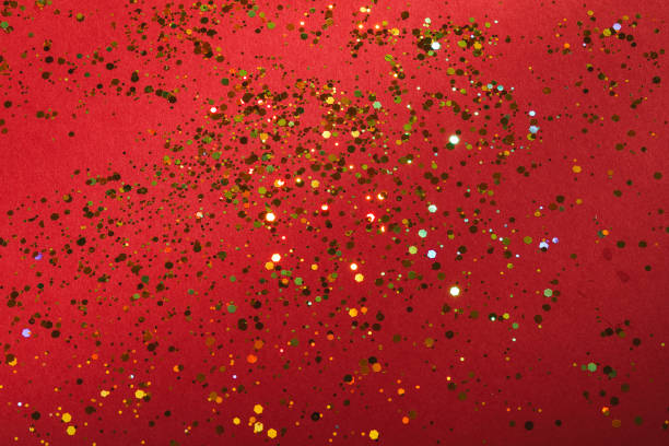 Red background with golden glitter spread - shiny holiday background texture