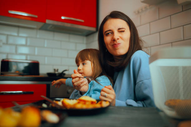 mutter kämpft mit kleinem kind, um sie zum essen zu überreden - eating obsessive child toddler stock-fotos und bilder