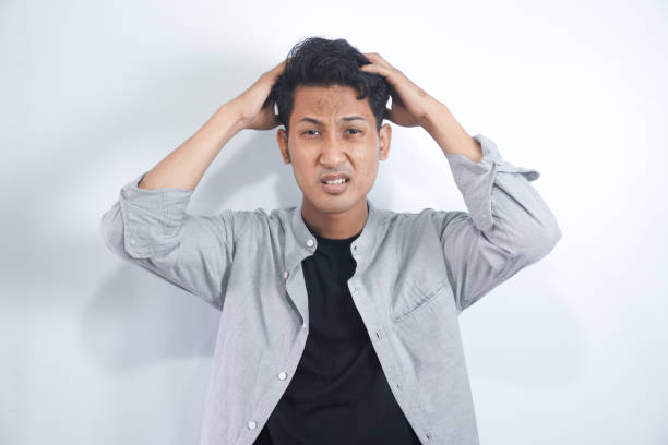 istock Young man with shirt having doubts and with confuse face expression while scratching head on isolated white background 2148470760