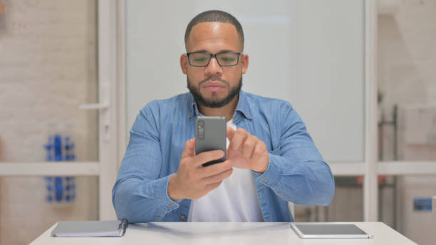 istock Mixed Race Man Browsing Internet on Phone 2148470787