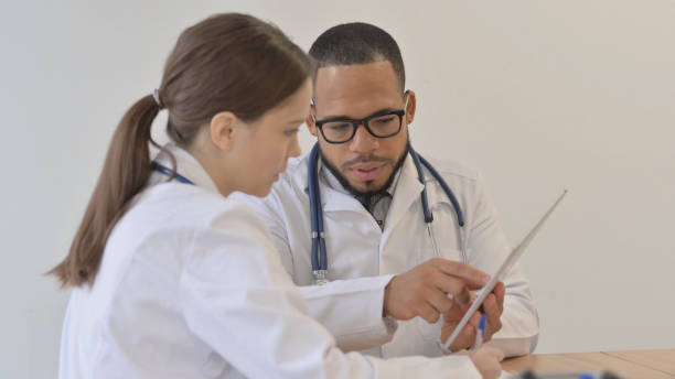 istock Team of Multi Ethnic Doctors Discussing Medical Report on Tablet 2148471733