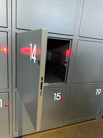 Stock photo showing close-up view of a wall of numbered stainless steel security locker boxes for valuables.