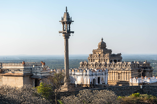 The image captures the majestic Chandragiri Hill temple complex at Shravanabelagola, bathed in the soft glow of the afternoon sun, highlighting its historical and architectural elegance.