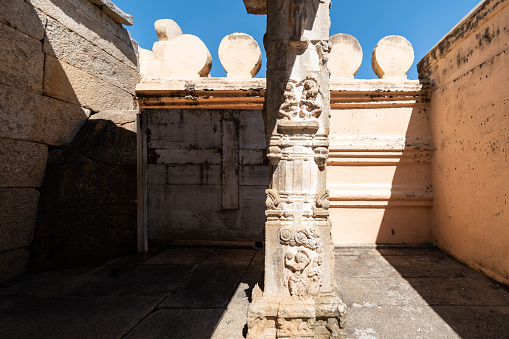 Carved stone pillar at Shravanabelagola showcasing detailed artistry in bright daylight.