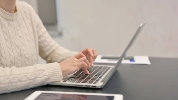 istock Side View of Female Hands Typing on Laptop 2148473934