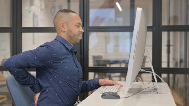 istock Hispanic Businessman with Back Pain Working on Computer 2148475781