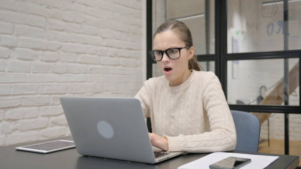 istock Creative Woman Shocked by Loss on Laptop at Work 2148476450