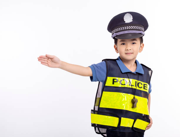 child dressed as a police officer standing before white background