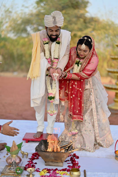 istock Indian bride and groom putting puffed rice into the havan during the wedding ceremony 2148476709
