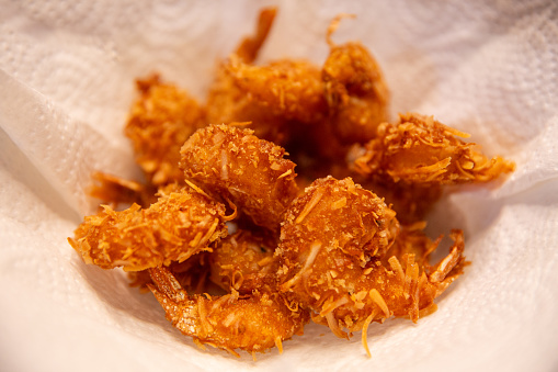 Fresh Fried Coconut Shrimp cooling on a napkin
