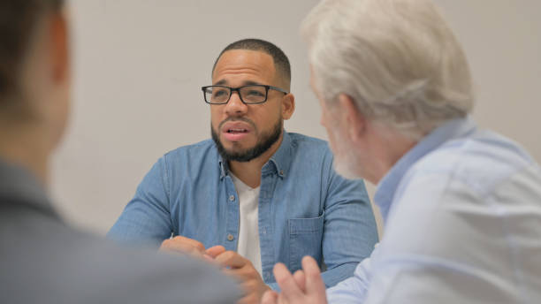 istock Close up of Hispanic Man Talking with Teammates 2148481706