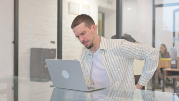 istock Creative Young Man having Back Pain in Office 2148484269