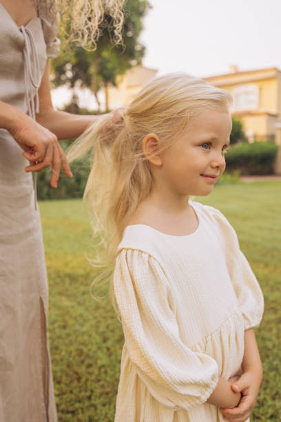 istock Mother carefully braids her daughter's hair 2148486530