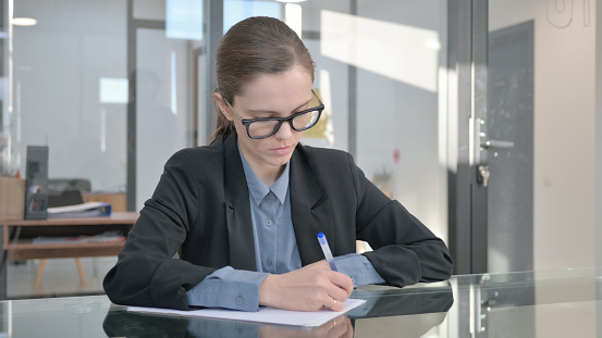 Young Businesswoman Writing a Letter in Office