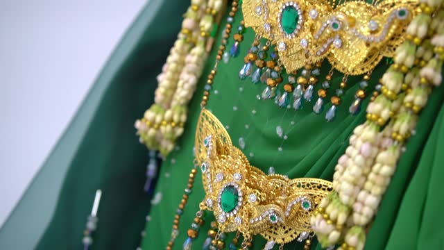 Traditional Indian bridal wear with intricate embroidery and jewelry, close-up on details.