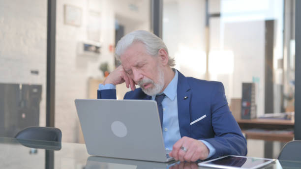 istock Old Businessman Sleeping in front of Laptop 2148488619