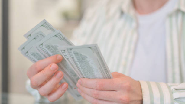 istock Close up of Hands Counting Money 2148488924