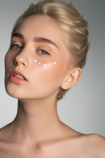 Beautiful girl using cream on her face