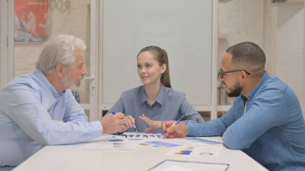 istock Young Woman Doing Paperwork with Team 2148490458