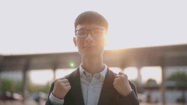 A portrait of a young man looking at the camera at sunset