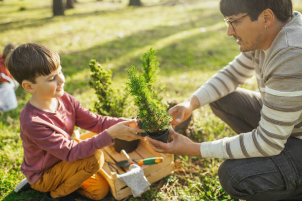 istock Father and son planting trees outdoors in springtime 2148492856