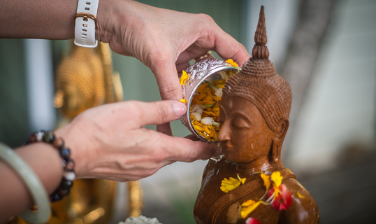 Songkran traditions in Thailand Thai Buddhists often take out Buddha statues in their homes and bathe them with Thai perfume and flowers on the first day of Songkran Festival.