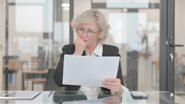 istock Senior Businesswoman Feeling Upset while Reading Contract 2148494873