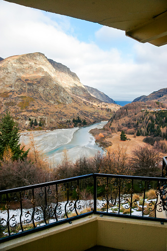 A beautiful blue green river passes through arid mountainous terrain in the middle of winter