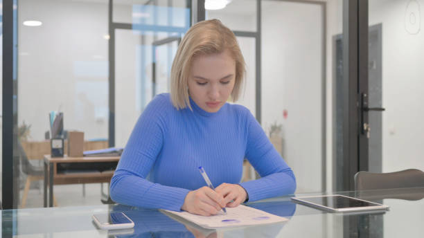 istock Young Woman Doing Paperwork in Office 2148497820