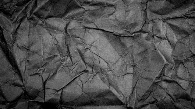 Stop motion animated paper texture background. Crumpled Black Paper Looping Animation in 4k