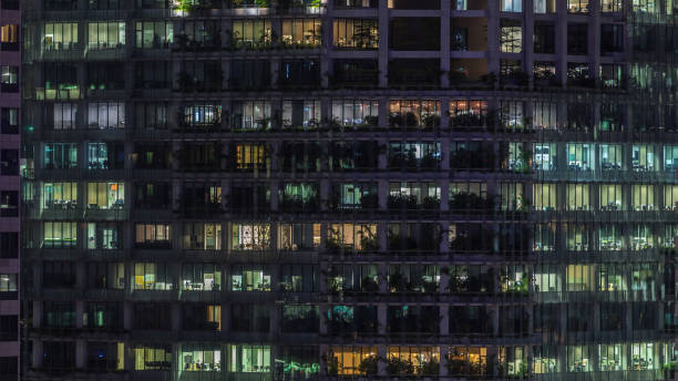 istock Modern office building with big windows at night timelapse, in windows light shines 2148498819