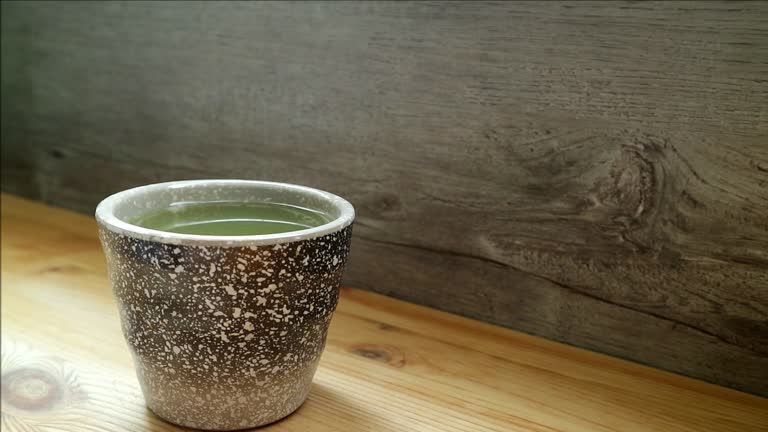 Footage of a Cup of Hot Coffee with Smoke on Wooden Table