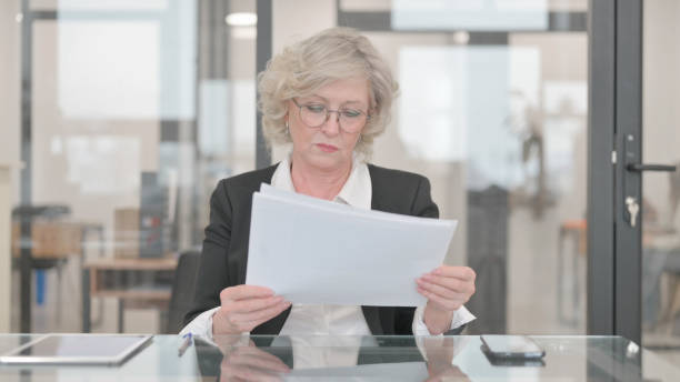 istock Senior Businesswoman Reading Documents at Work 2148500347