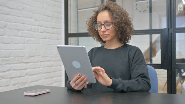 istock Hispanic Woman Working on Digital Tablet 2148501434
