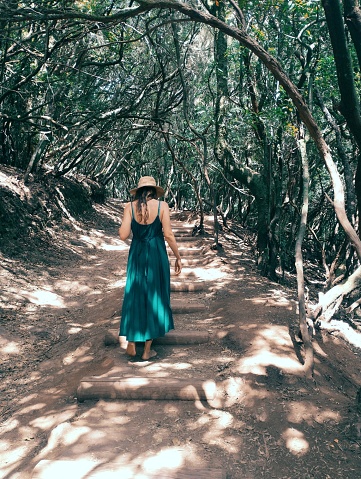 Mujer con vestido caminando por el bosque