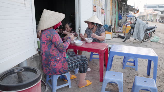 Vietnamese women eating a pho bo, South Vietnam