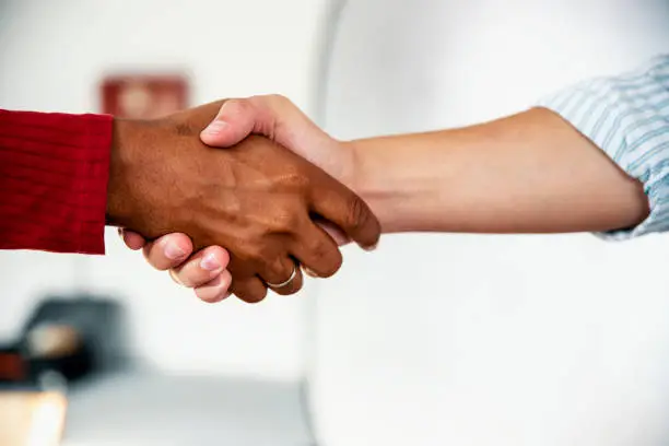 Multiracial Partners shaking hands, congratulating on successful business. Close up