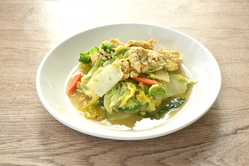 fried white Chinese cabbage with egg in soy sauce on plate