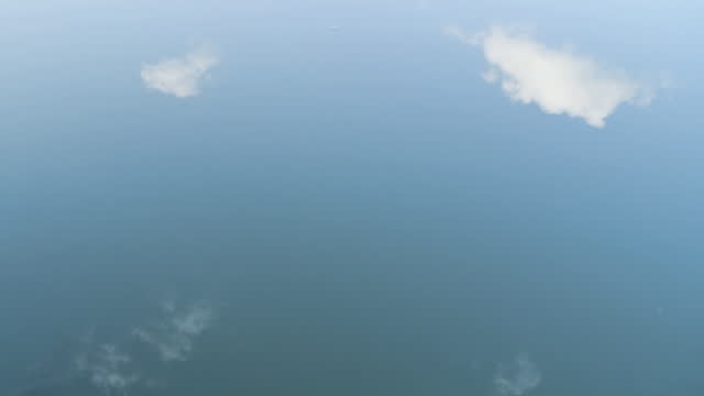Reflection of clouds in the Water . 
Water in a lake and cloud reflections. Background