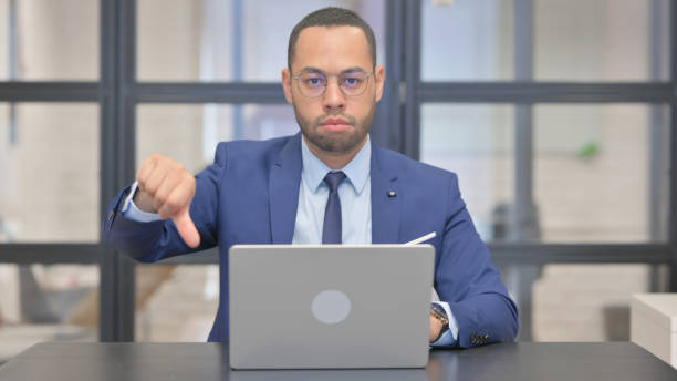 istock Thumbs Down by Mixed Race Businessman Using Laptop 2148510139