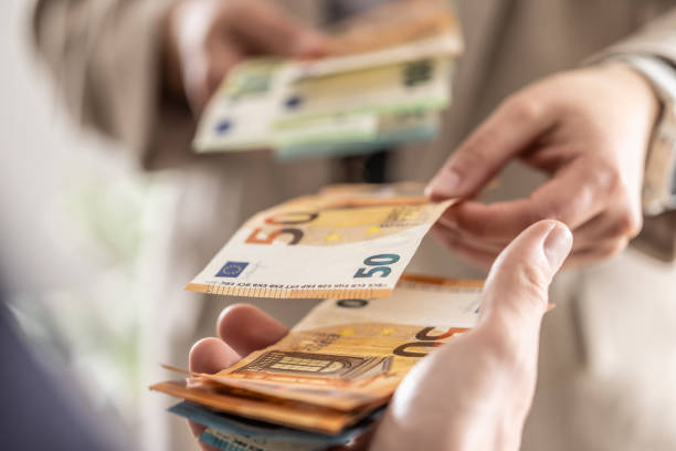 istock Businesswoman's hands exchanging euro banknotes, closeup shot. 2148510690