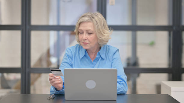 istock Old Businesswoman Enjoying Online Banking at Work 2148511227