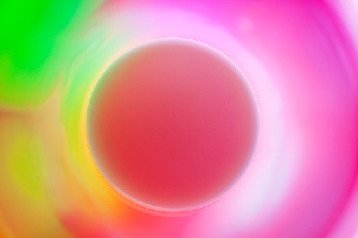 Milk with colored lights creating abstract sphere with a corona.