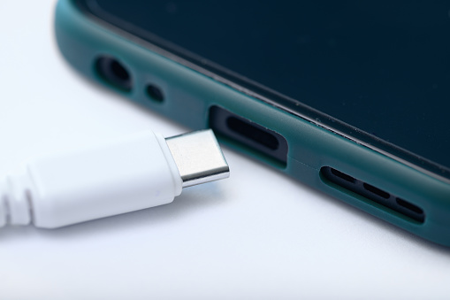 Phone charger, USB Type-C cable plugged into the smartphone input, close-up
