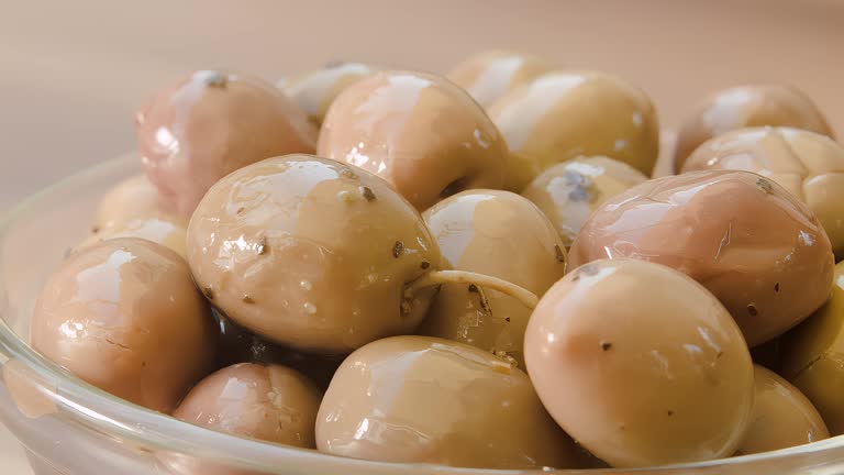Close-up of white pickled olives in a glass bowl