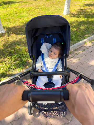 Baby sleeping in the stroller in the park
