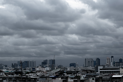 A city skyline is shown with a cloudy sky. The city is filled with tall buildings and the sky is overcast