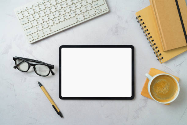 istock Digital tablet mock up, coffee cup, notebooks and computer keyboard on modern office desk. Top view, flat lay 2148517739