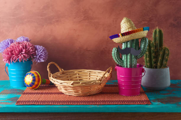 istock Empty wicker basket on wooden blue table with cactus decoration over wall  background. Mexican party mock up for design and product display 2148517755